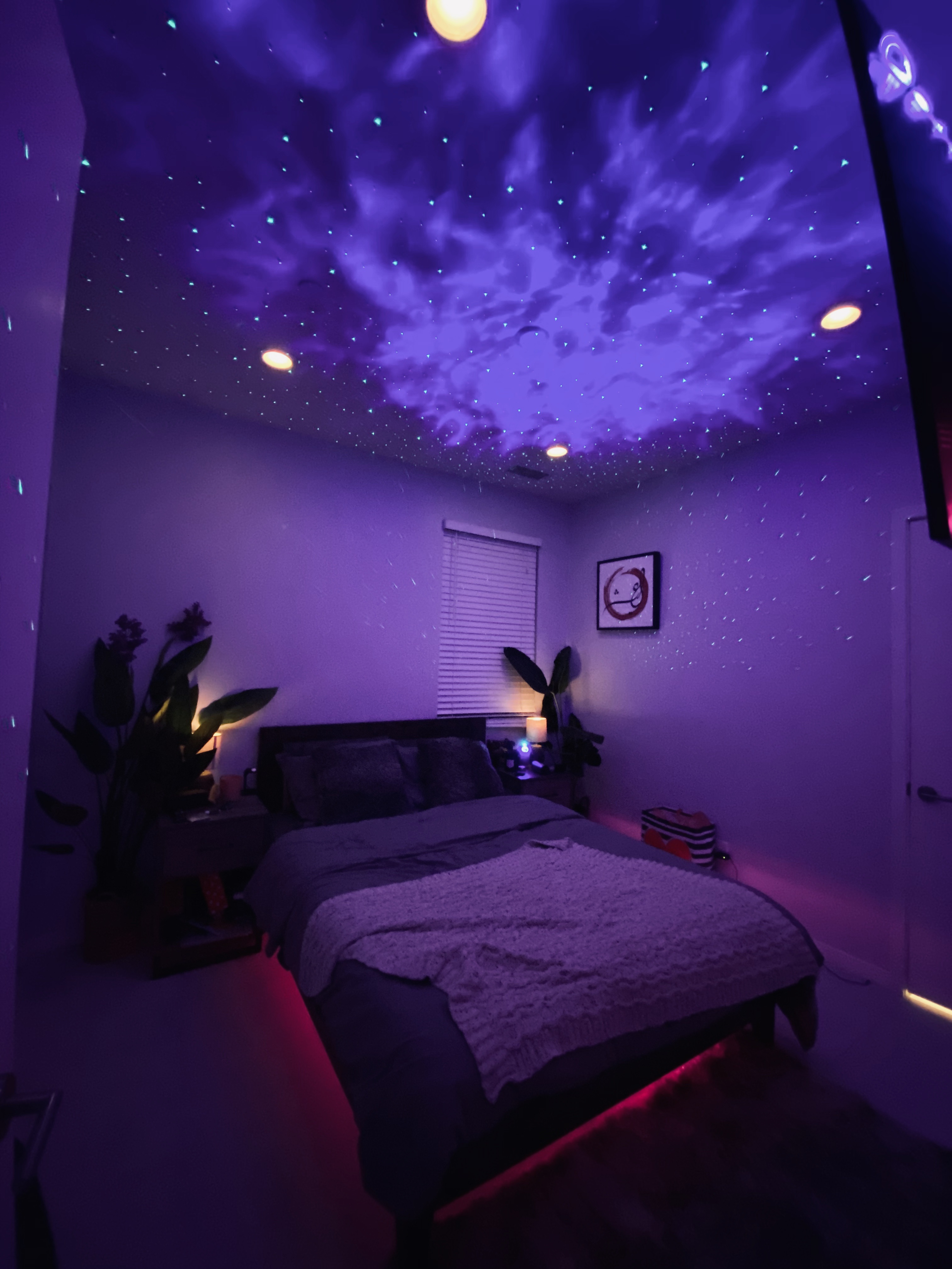 BlissLights Sky Lite projecting laser stars and nebula onto a dark bedroom ceiling
